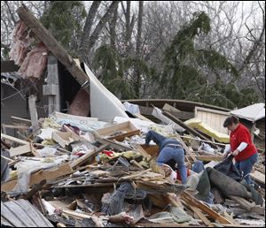 Residents look through a house where a women was killed in Moscow, Ohio, Saturday.