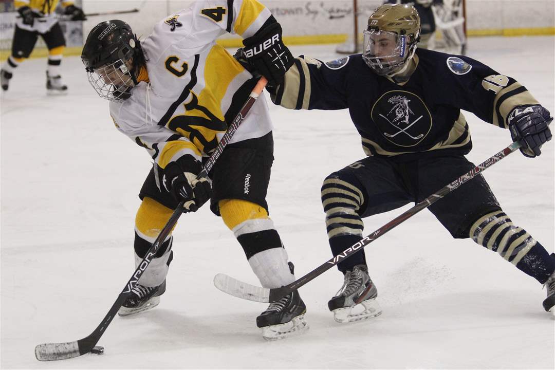 Sylvania-Northview-player-Kyler-Omey-4-keeps-the-puck-from-Toledo-St-John-s-Jesuit-player-Colin-Suter