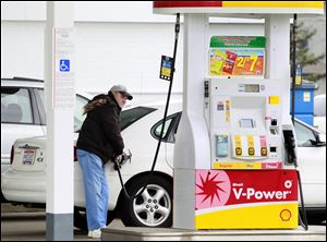 Chester Hall of Sylvania Township fills up his Ford Taurus at a Shell station on West Central Avenue. Though there's not a rush for smaller cars, dealers and analysts still expect increased demand.