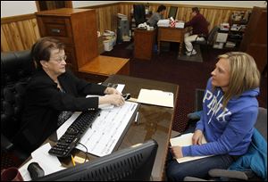 Donna Russell, co-owner of All Pro Tax & Accounting Service, helps Michelle Ranes of Holland prepare her taxes.