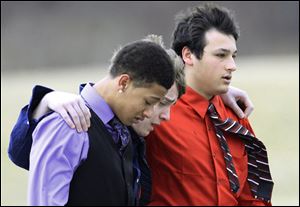 Three youths comfort each other after the burial of Daniel Parmertor, 16, one of the three students killed in the shooting at Chardon High School last week.