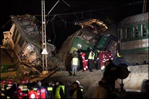 Rescue officials work at the scene where two trains collided in Szczekociny, southern Poland, killing several people and injuring dozens of others, Saturday evening.