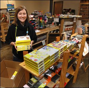 Jules Webster, co-owner of Art Supply Depo, stocks shelves. The other store for the cash mob is Meats and More & The Beer and Wine Cave.