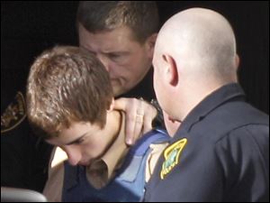 T.J. Lane, 17, is taken out of Geauga County Juvenile Court  in Chardon, Ohio on Tuesday, following a hearing in the shooting deaths of three students in the cafeteria of Chardon High School last week.  