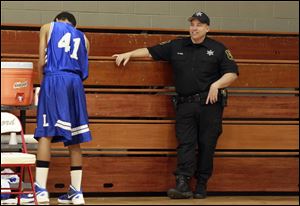 Deputy Randy Sehl works security in the gym during a Bedford High School basketball game on March 1. School officials, parents, and residents say Deputy Sehl and the other school resource officer, Randy Krupp, bring a positive influence to the school system.
