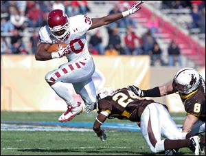 Temple running back Bernard Pierce (30) leaps over Wyoming defensive back Kenny Browder (24) and linebacker Brian Hendricks (8) in the 2011 New Mexico Bowl in Albuquerque, N.M.