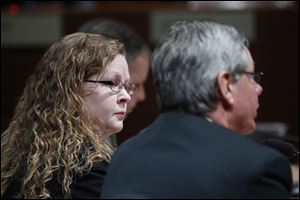 Julie Lyle, the Lucas County dog warden, listens as County Commissioner Pete Gerken  speaks in a Toledo City Council committee meeting.