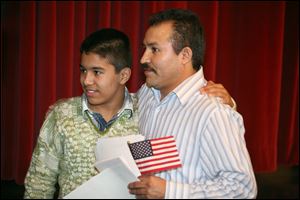 Israel Longoria, 13, stands with his father Joaquin Longoria Caldera after his father became and American citizen.