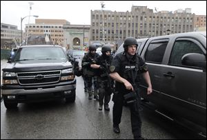 Police in SWAT gear make their way up the street to the Western Psychiatric Institute. Three University of Pittsburgh police officers traded fire with the shooter.