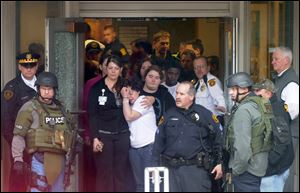 People crowd the doorway at the main entrance to the facility as they wait to be evacuated from the scene. The UPMC hospitals were put on alert at 1:58 p.m. that a gunman had entered the building.