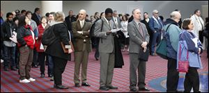 Job seekers stand line during a Career Expo job fair in Portland, Ore. 