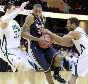 Toledo's Reese Holliday tries to get the ball to the hoop against Ohio University's Jon Smith, left, and Nick Kellogg during mens basketball quarterfinal Thursday night.
