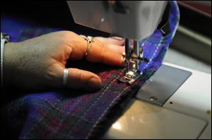 Aida Acosta, of Hartford, Connecticut, uses a sewing machine to work on a cape she is making.