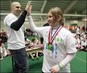 Cincinnati Bengals quarterback Bruce Gradkowski, a University of Toledo alumnus, congratulates Hannah Smoyer of Haskins Elementary School during the Wood County Youth Olympics at Bowling Green State University's Perry Field House. 