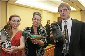 Drew Longmore, 13, a student at TSA, left, with her mother Belinda Longmore, both of Toledo, and Mark Spang, of Plate 21, show off shoes at 