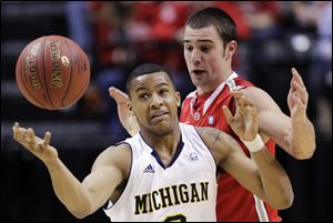 Michigan guard Trey Burke (3) battles for a loose ball against Ohio State guard Aaron Craft (4) in the first half of an NCAA college basketball game in the semifinals of the Big Ten Conference tournament in Indianapolis, Saturday.