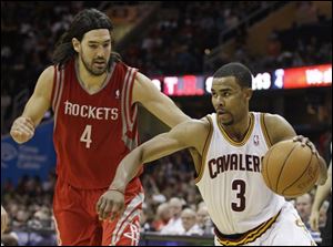 The Cavaliers' Ramon Sessions (3) drives past the Rockets' Luis Scola (4) in the fourth quarter.