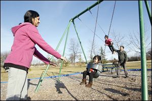 Bhagyashri Patil pushes her daughter Gargi, 2, while her husband Sunil pushes their other daughter, Manasvi, 6, during an outing in Perrysburg's Woodlands Park.