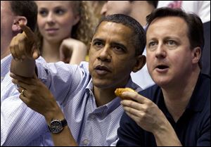 President Obama guides British Prime Minister David Cameron's view of the action on the basketball court as Mississippi Valley State battles Western Kentucky in the first round of the NCAA tourney at the University of Dayton.