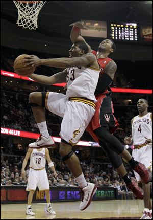 The Raptors' James Johnson, right, fouls the Cavs' Alonzo Gee as he goes for the basket in the first quarter.
