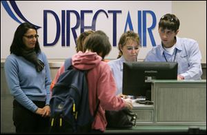 DirectAir employees Sherry Andrews, second from right, and colleague Drew Schmalzreid, right, check passengers in for the first DirectAir flight from Toledo Express Airport in November, 2008. The airline said Tuesday it missed a payment to a fuel supplier and the firm cut it off.