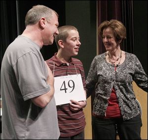Spencer Hipsher, 13, is flanked by his proud parents, Ron and Lynn Hipsher, after he spelled lenitive correctly to win the spelling bee.