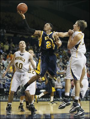 Whitmer's LeRoy Alexander goes to the basket against Norwalk's Jake Fetherolf in a Division I regional semifinal at the University of Toledo's Savage Arena. Alexander had nine points and eight rebounds as the Panthers improved to 22-2.