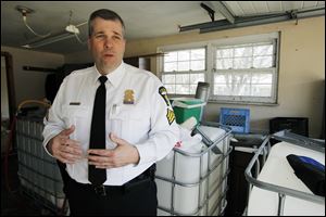 Toledo Police Sgt. Joe Heffernan answers questions about moonshine still paraphernalia found in the garage of a South Toledo home, where Municipal Court bailiffs were executing an eviction process.