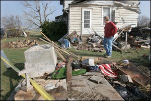Jack VanDyke walks in the backyard of the Montri family farmhouse that was hit by a tornado Thursday night. The  Monroe, MI  area was hit by large storms, hail and a tornado causing damage  to the Montri family farmhouse on Ida Center Road in Ida Township, Mich.