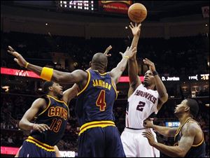 The Hawks' Joe Johnson (2) shoots while defended by the Cavaliers' Tristan Thompson (13), Antawn Jamison (4), and Alonzo Gee.
