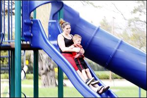 Amanda Houston and her son Joshua Brooks, 4, from Toledo, play on the slide in Walbridge Park on March 19, 2012.