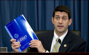 House Budget Committee Chairman Rep. Paul Ryan (R, Wis.) holds up a copy of President Barack Obama's fiscal 2013 federal budget on Capitol Hill in Washington. The Republicans plan to unveil their budget plan Tuesday.
