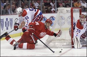 Detroit's Todd Bertuzzi, defended by Jeff Schultz, tries to slip the puck past Washington goalie Braden Holtby.