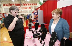 Pam Hart of Toledo, left, looks at some jewelry with help from Joanne Earnest, of Perrysburg, at the Kismet Jewelry Design booth at the Bedford Trade Fair.