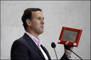 GOP presidential candidate Rick Santorum holds an Etch A Sketch at a campaign stop in San Antonio. Mr. Santorum, Mitt Romney's closest competitor, bought several of the children's toys at a store in Louisiana.