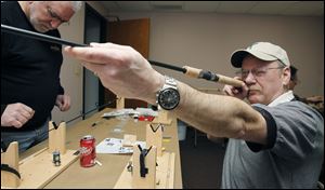 Whitehouse resident Denny McLean makes sure his guides are straight during a fishing rod building class at Netcraft in Maumee, Ohio. At left, is Temperance resident Rick Boehme.