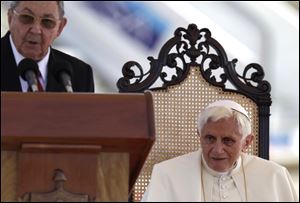 Pope Benedict XVI sits as Cuba's President Raul Castro speaks during his welcome ceremony at the airport in Santiago de Cuba, Cuba, on Monday.
