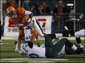 Ohio defensive end  Tremayne Scott, 90, trips up Bowling Green's Anthon Samuel, 6, during a game at Bowling Green.