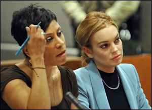 Lindsay Lohan, right, sits with her attorney Shawn Chapman Holley during a progress report on her probation for theft charges at Los Angeles Superior Court Thursday.