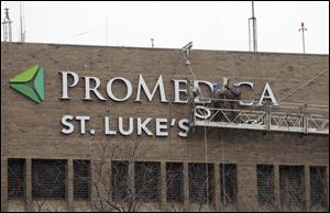 Workers erect a ProMedica sign on St. Luke's Hospital in Maumee in December. The hospital remains part of Promedica during the appeal process. 
