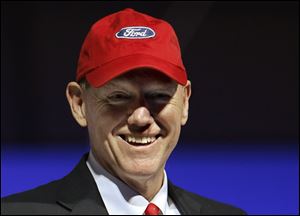 Ford Motor Co. President and Chief Executive Officer Alan Mulally dons a cap bearing the Ford 