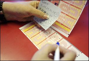 A woman fills out her numbers for the Mega Million Jackpot on Thursday at the Town and Country in McAllen, Texas.