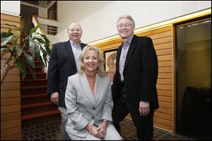 Joe Sharp, left, and Judy McFarland, chief executive officer and president, respectively, of Thread Marketing Group, gather with Mark Luetke, FLS Marketing president, at the merged firm's new offices.