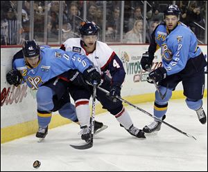 Walleye's Derek Brochu (42) steals the puck from Kalamazoo's Jonathan Harty (4) during an ECHL game Saturday at the Huntington Center in Toledo, Ohio.