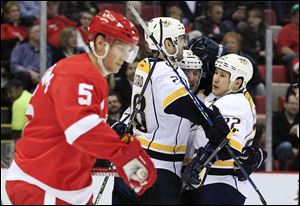 The Red Wings' Nick Lidstrom, left, skates past a group of celebrating Predators after Gabriel Bourque (center) scored in the second period.