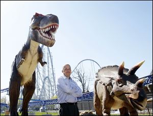 Cedar Fair CEO Matt Ouimet stands near a few of the new animatronic dinosaurs that will be on exhibit at Cedar Point this year.
