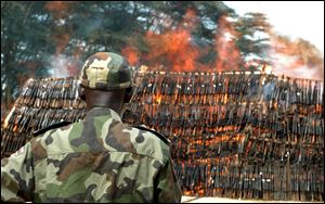In this photo taken Oct. 5, 2009, soldiers of the Uganda Peoples Defence Army burn a heap of about 3,500 confiscated illegal arms recovered from Lords Resistance Army rebels' caches and robbers throughout Uganda.