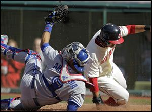 Toronto Blue Jays catcher J.P. Arencibia (9) tags out Cleveland Indians' Shin-Soo Choo trying to score on a passed ball in the third inning of a baseball game in Cleveland on Thursday.