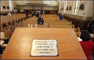 Volunteers fan out in the sanctuary of St. Rose Catholic Church to prepare it for Holy Week services. Msgr. Marvin Borger said the damage from Tuesday’s fire ‘was not anything we can’t handle.’
