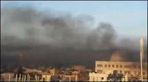 This image made from amateur video and released Wednesday by Shaam News Network purports to show black smoke from shelling billowing into the sky air in Aleppo, Syria.
